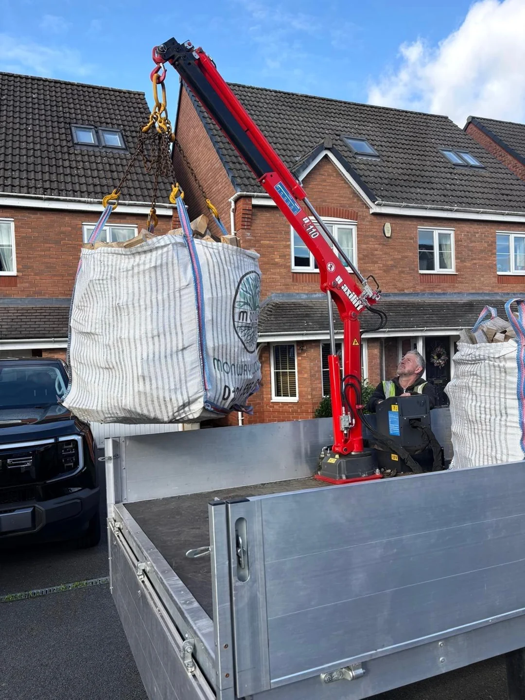 Vehicle-mounted crane lifting a Monway Woodfuel bulk bag